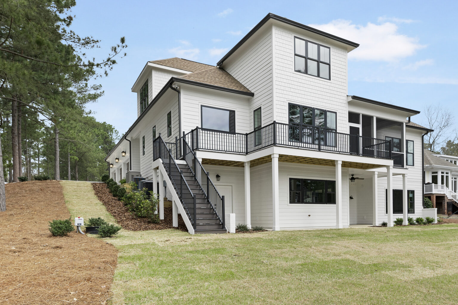 Lakeside custom home on Lake Auman in Seven Lakes NC with black railings and outdoor stairs