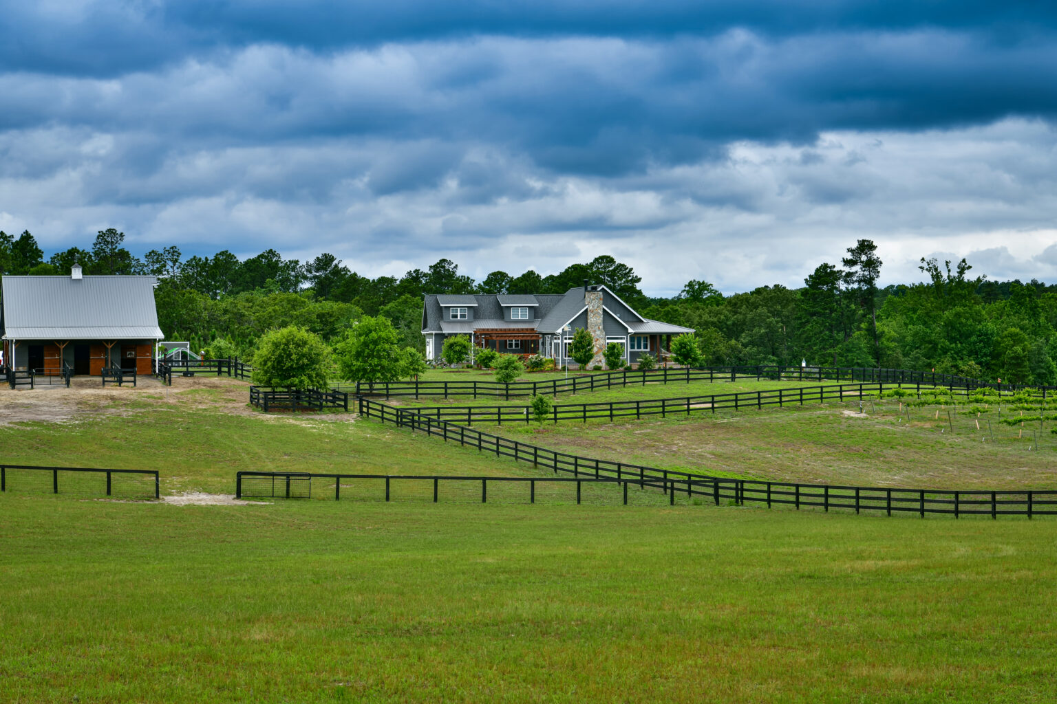 Kunce residence and equestrian barn set among fenced pastures at Magnolia Lane Farms