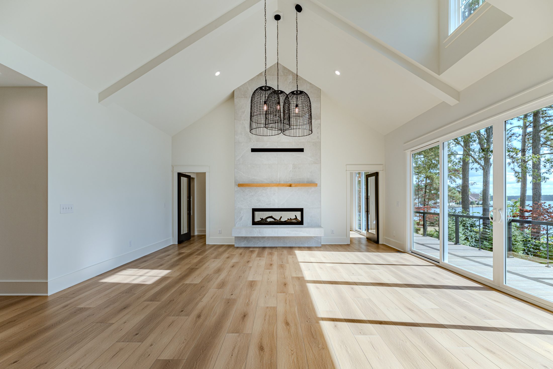 Bright vaulted living room with fireplace and expansive windows