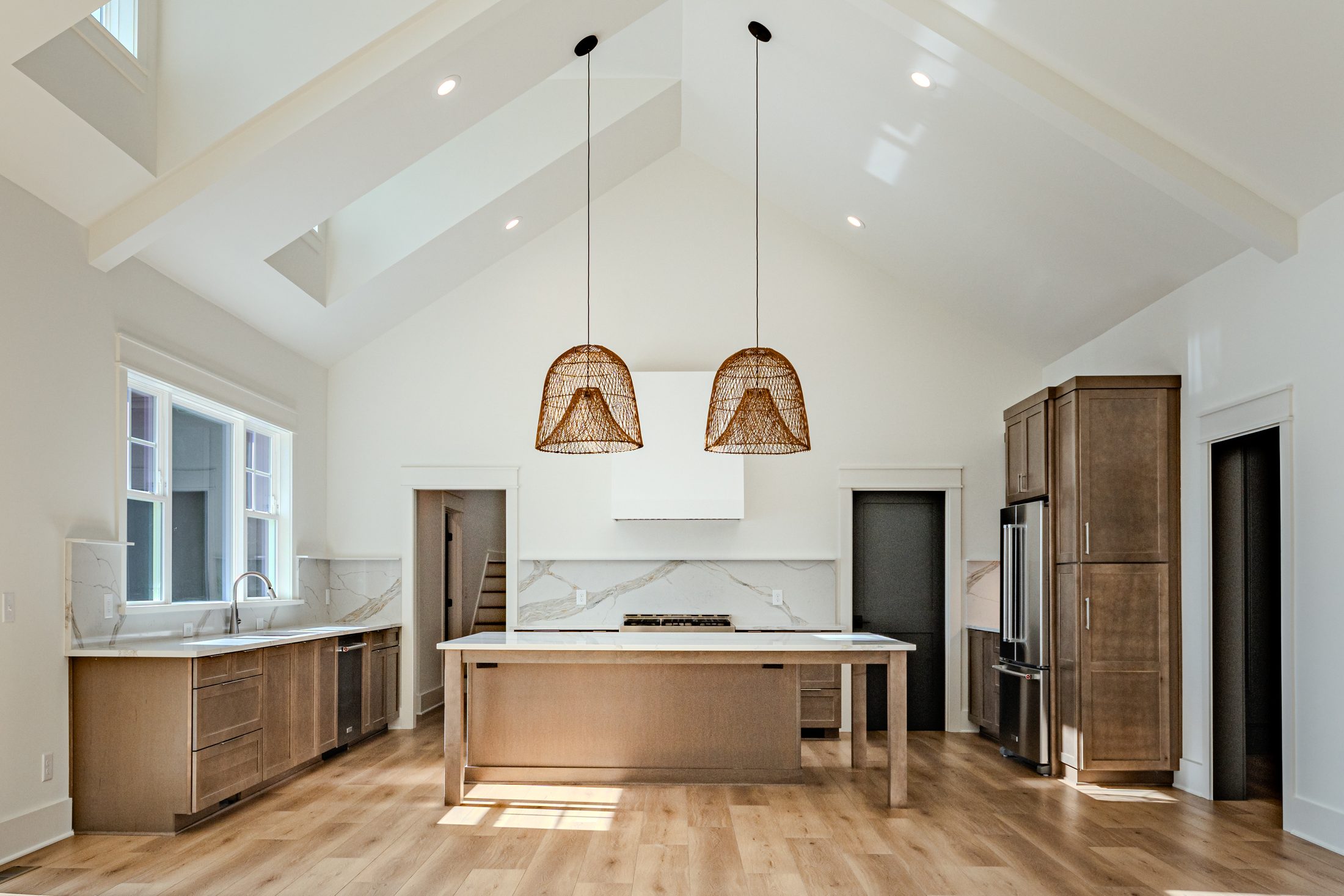 Open great room and kitchen with vaulted ceiling and lake views