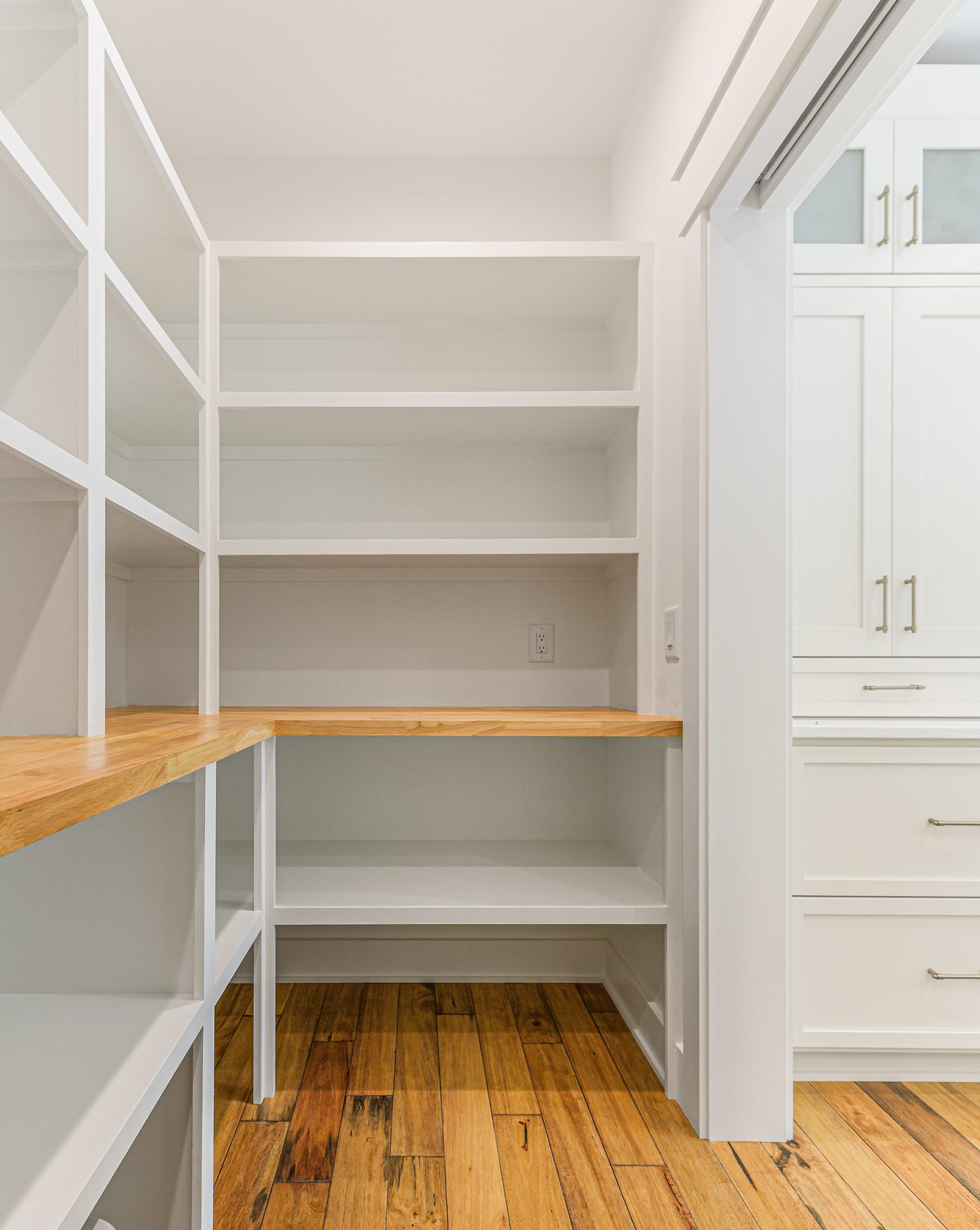 Walk-in pantry with built-in shelving and wood countertop