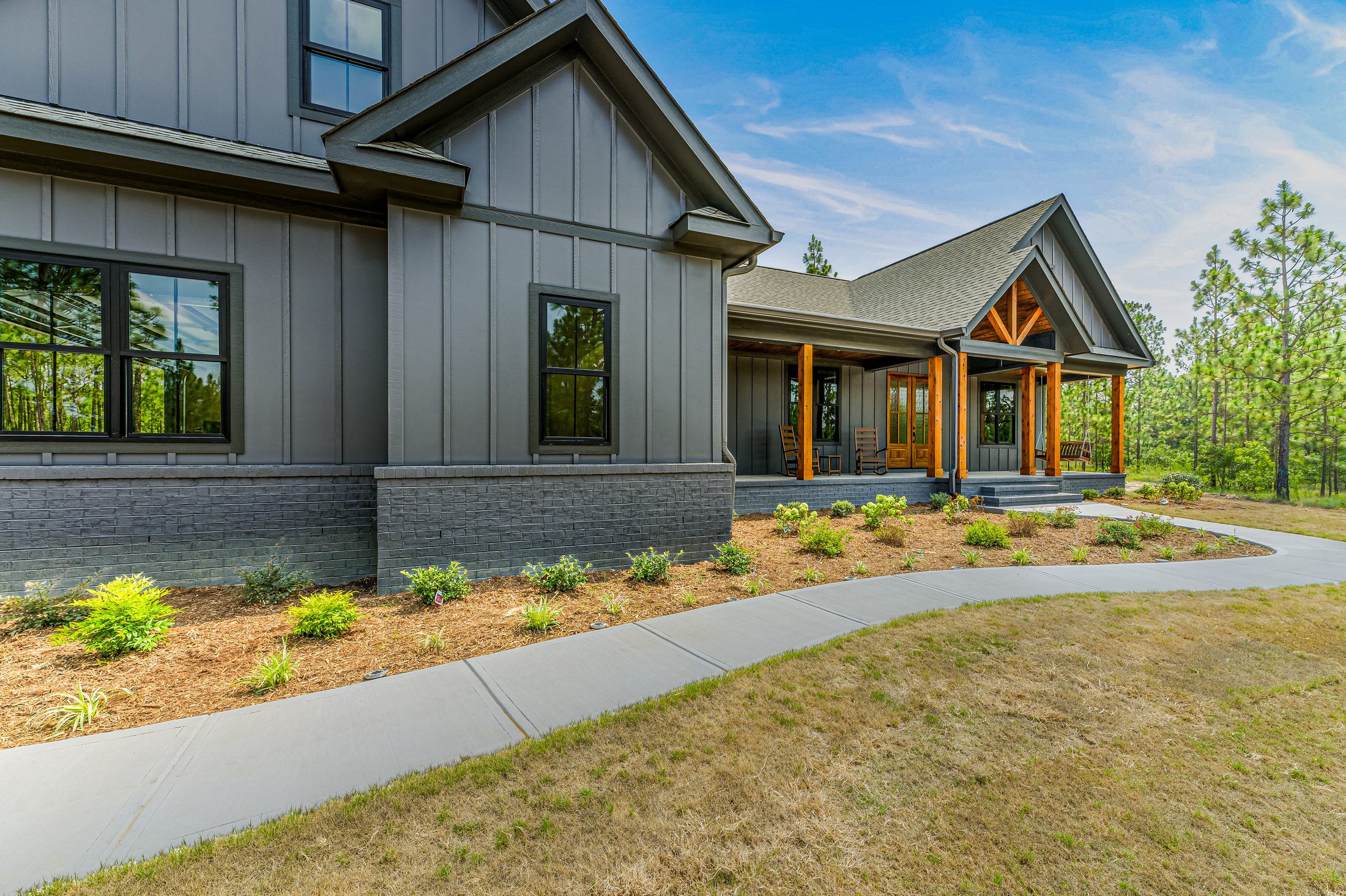 Angled front exterior with dark siding and timber entry in West End, North Carolina