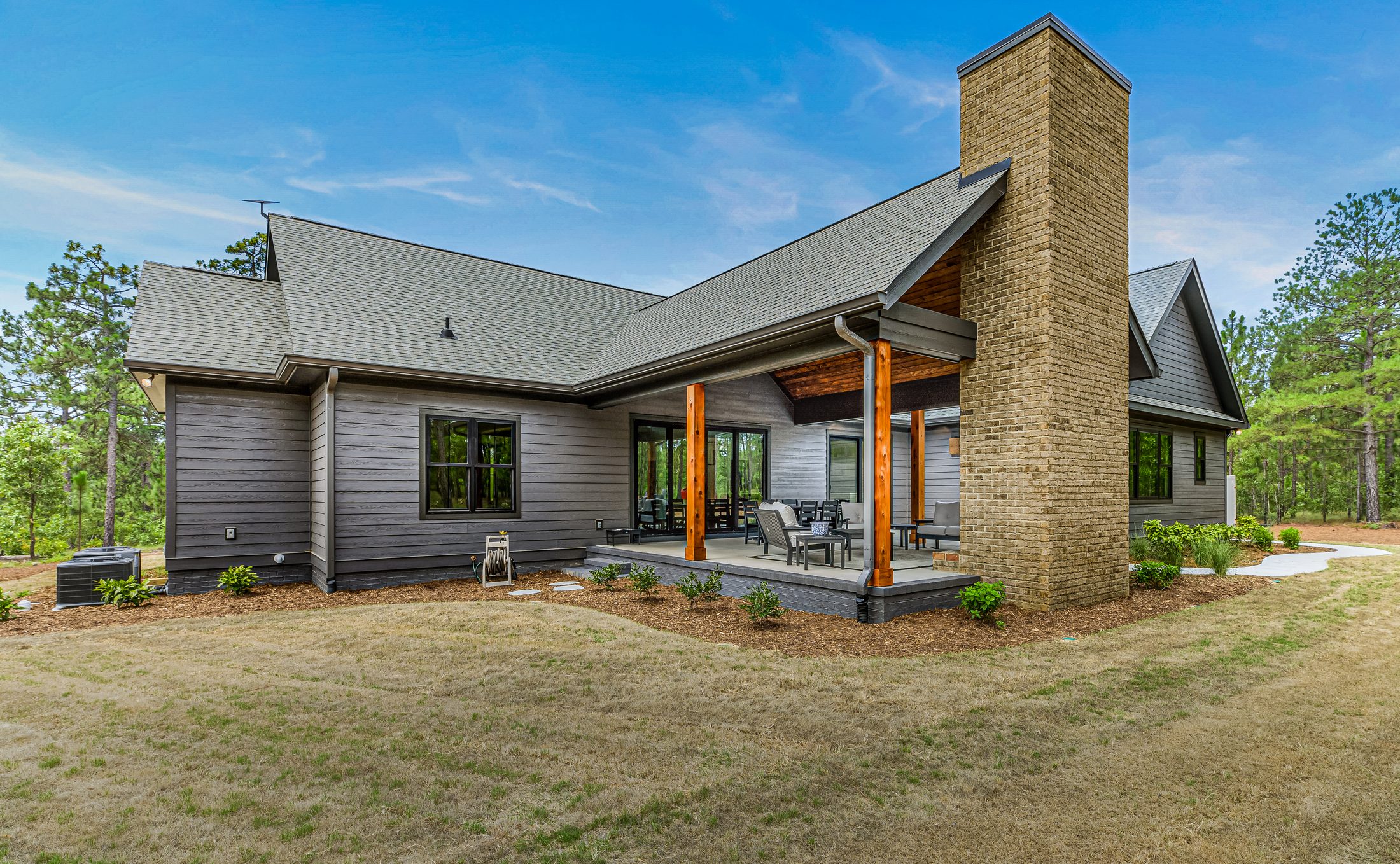 Rear exterior with brick chimney and covered outdoor living area