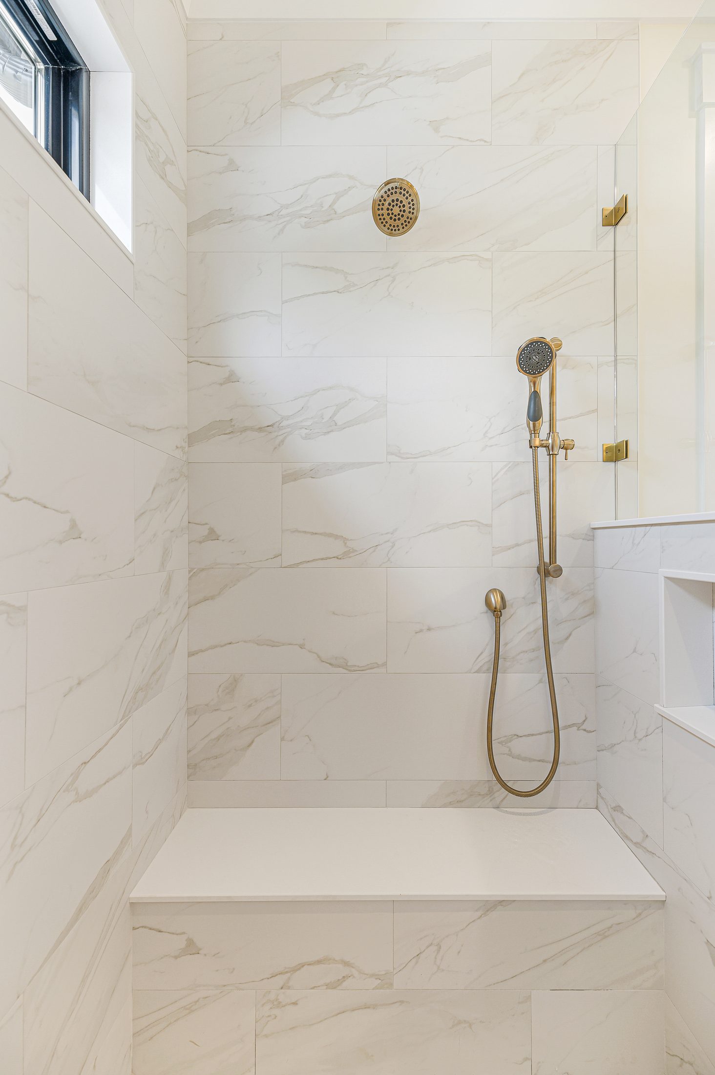 Primary shower with large-format tile in a Arbor Creek custom home in West End