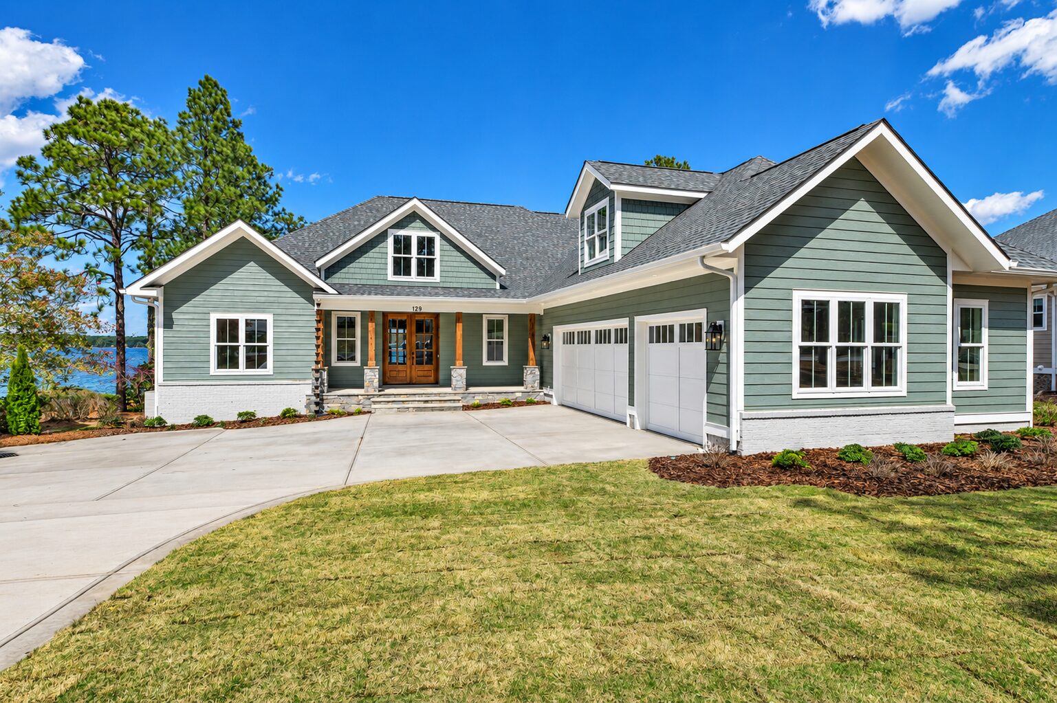 Poolside custom home on Lake Auman in Seven Lakes NC with sage siding and timber entry